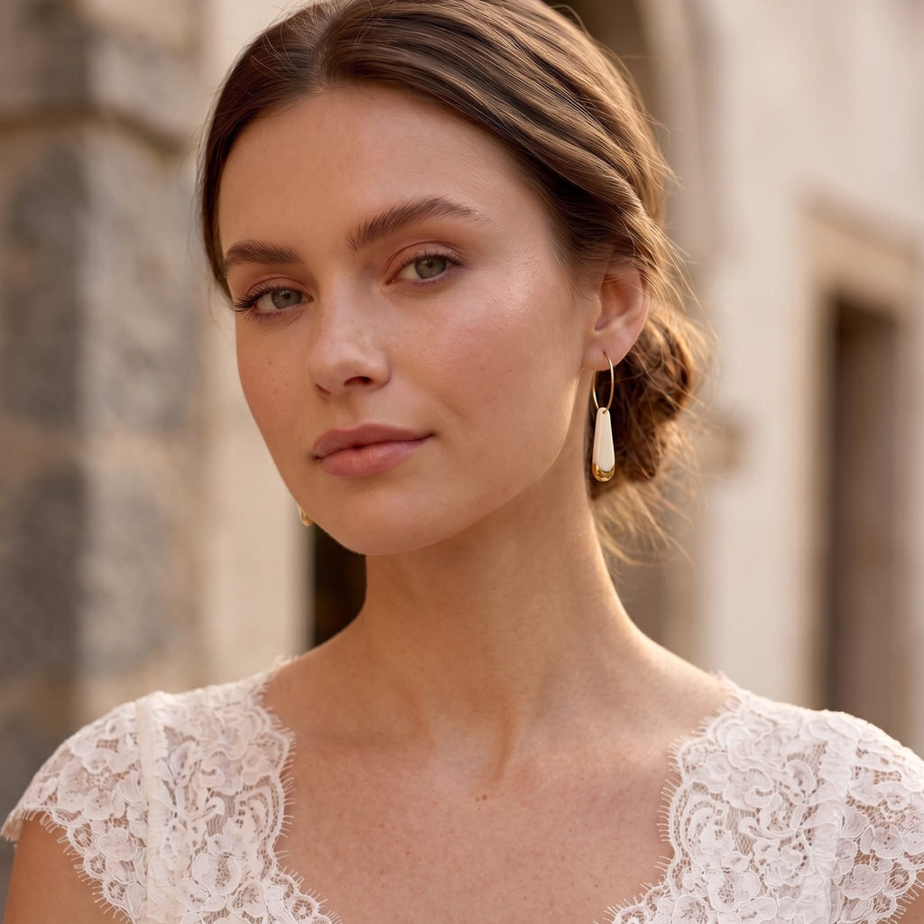 Jeune mariée portant des boucles d'oreilles créoles en porcelaine blanche et or