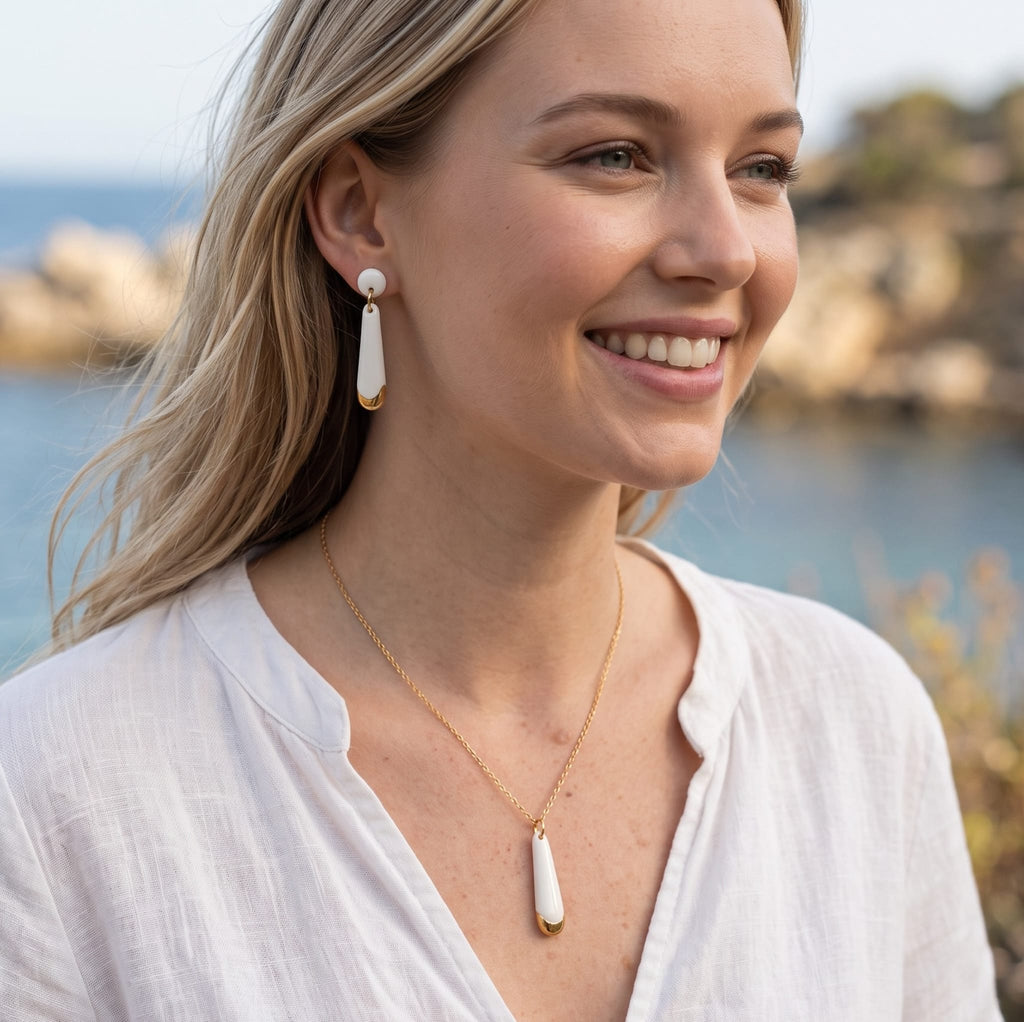 Boucles d'oreilles en porcelaine et or portées par une jeune femme
