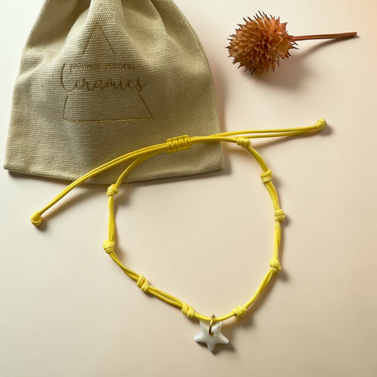 Bracelet cordon jaune et pendentif en porcelaine blanche – ajustable posé avec étui beige