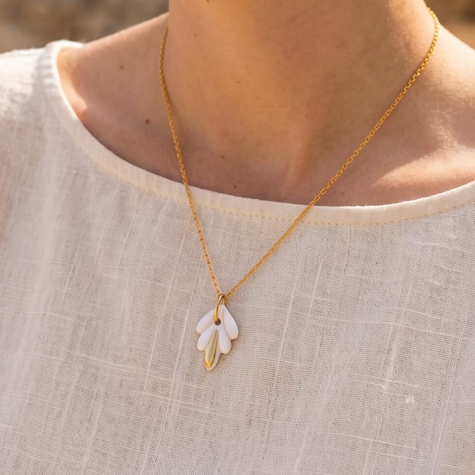 Collier lys en porcelaine blanche et or porté, chaîne dorée fine, bijou céramique fait main
