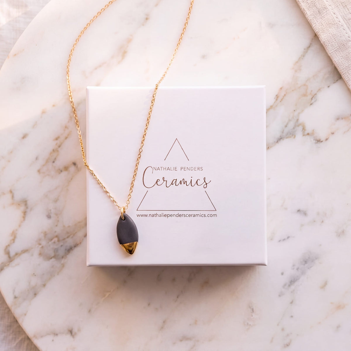 Collier pendentif ovale en porcelaine noire et or