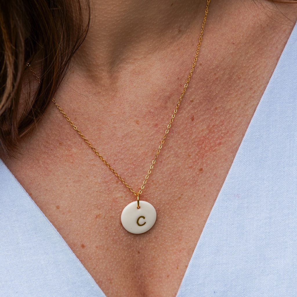 Collier lettre dorée en porcelaine blanche